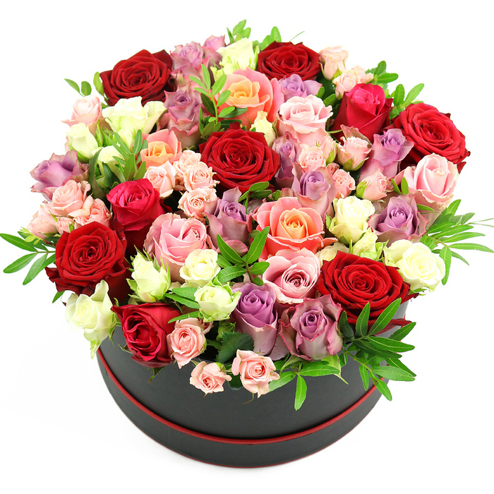 In this image, a richly detailed rose hatbox arrangement appears almost sculptural, set crisply against a white background so every nuance of colour and form is easy to imagine. The container is a sleek, black cylindrical hat box with a fine red trim circling its base, reminiscent of a chic gift you might pick up near Camberwell Church Street or the cafés around Camberwell Green. From this stylish base, roses are packed so abundantly that they billow out in a rounded, dome-like crown, rising high and spilling over the edges. At the centre and threading throughout are deep crimson and scarlet red roses, their petals velvety and full, suggesting passion, commitment, and timeless romance. Around them cluster roses in romantic fuchsia and soft blush pinks, warm coral and delicate peach tones, each shade blending seamlessly into the next like an evening sky over SE5. Creamy white and ivory roses offer contrast and light, while scattered lavender and muted purple blooms lend a refined, slightly whimsical accent. The roses vary in size and maturity: some are large, fully opened blossoms revealing complex, layered hearts; others are smaller buds and spray roses, still partly closed, bringing texture and a sense of unfolding stories. Tucked among the petals are small sprigs of glossy green foliage, likely ruscus or similar filler greenery, adding gentle structure and framing the blooms without overpowering them. The hatbox itself remains visible at the base, grounding the exuberant flowers and enhancing the impression of a premium floral gift. This arrangement, composed with the practiced eye of an experienced Camberwell florist, feels perfect for delivering heartfelt congratulations, anniversary love, or a grand birthday gesture to homes and studios throughout the local area.